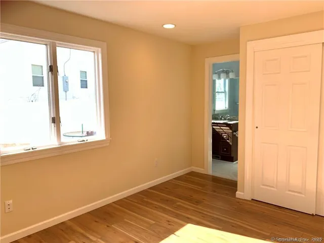 a view of a room with wooden floor and a window