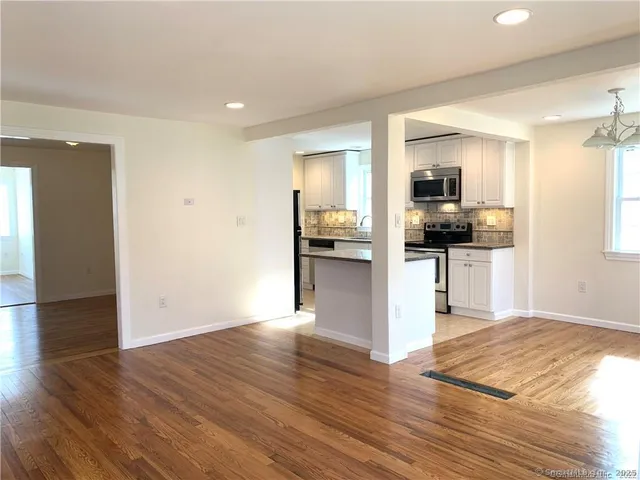 a view of kitchen with refrigerator microwave and wooden floor
