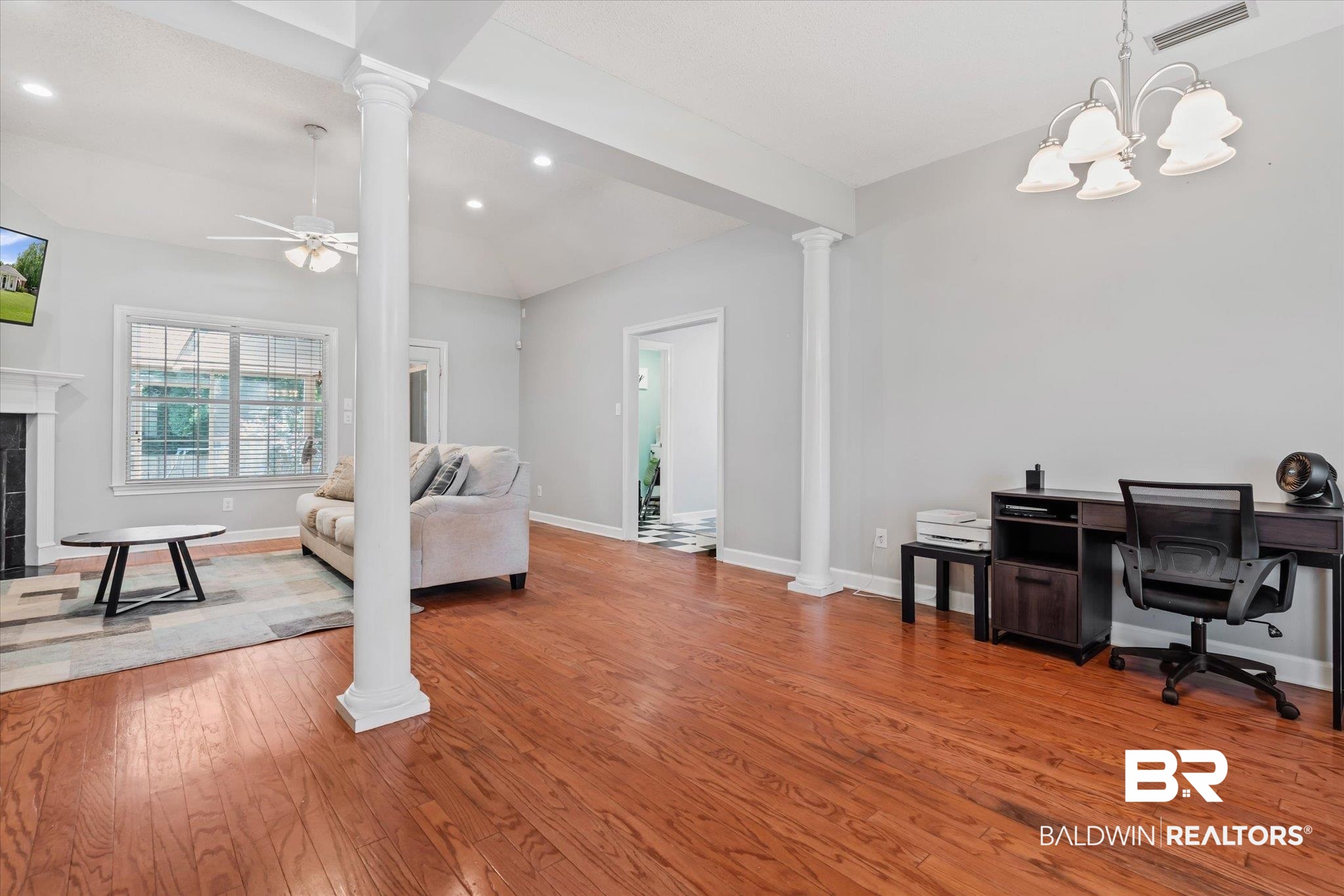 2320 Sequoya Trail Mobile, AL 36695 - Photo 3 of 20 Interior space featuring ornate columns, a tile fireplace, ceiling fan with notable chandelier, and hardwood / wood-style floors