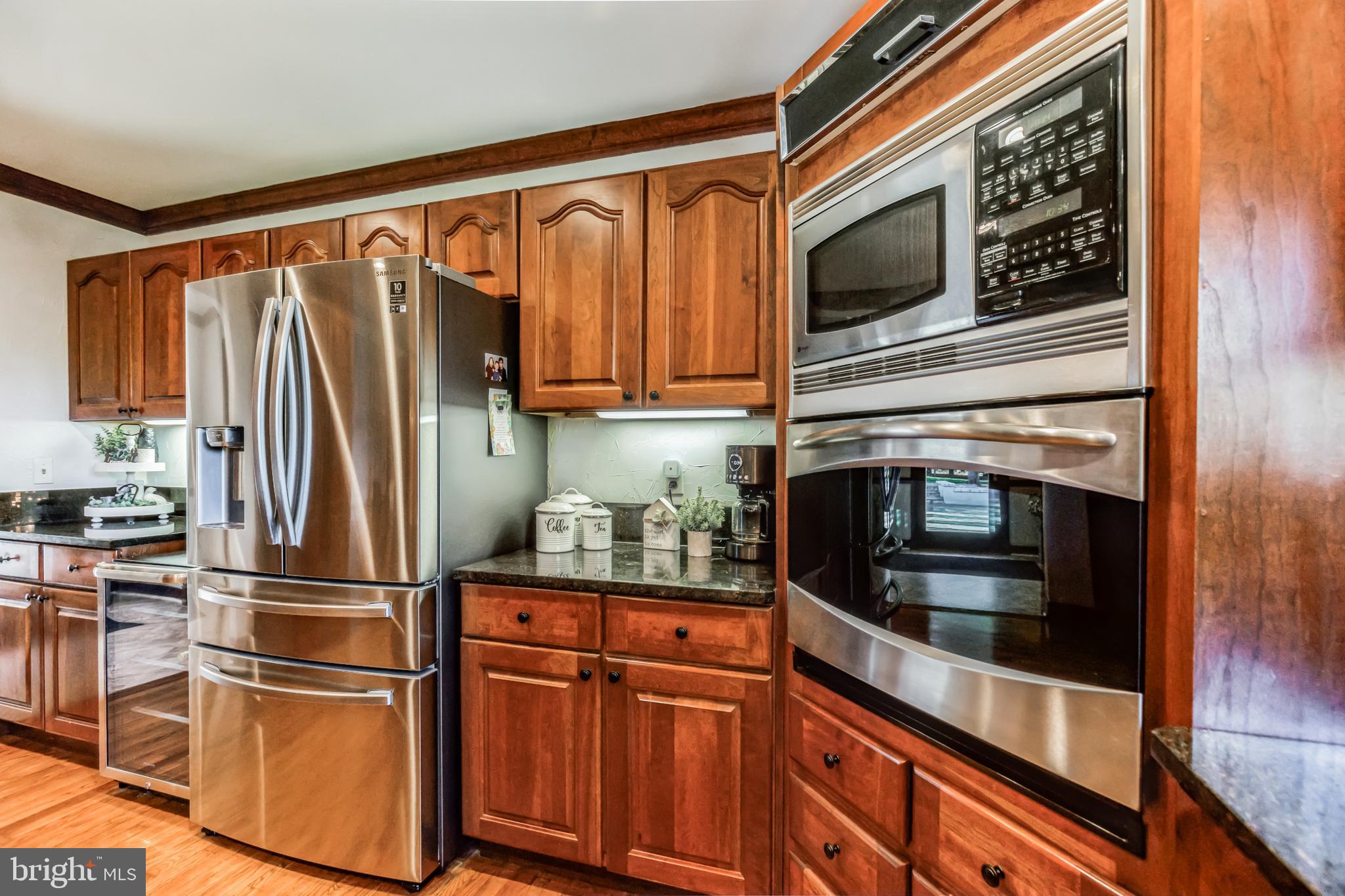 3310 Holland Cliffs Road Huntingtown, MD 20639 - Photo 16 of 40 a kitchen with stainless steel appliances granite countertop a refrigerator microwave and stove top oven