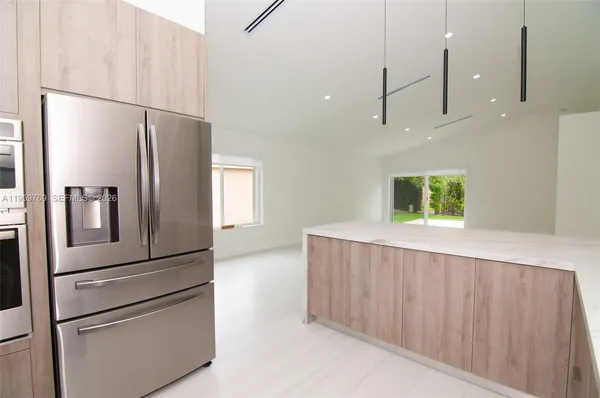 a kitchen with stainless steel appliances granite countertop a refrigerator and a microwave