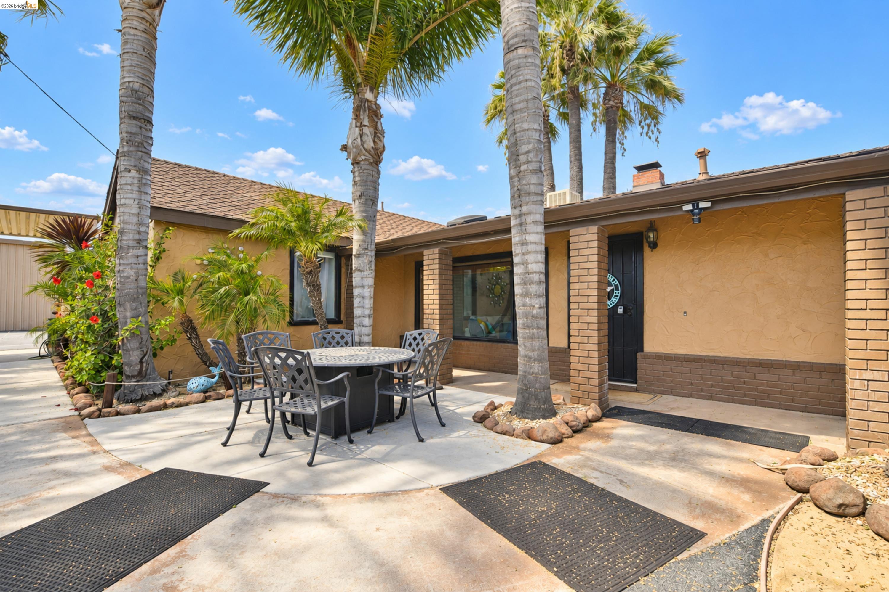 340 West Bolton Road Oakley, CA 94561 - Photo 10 of 87 Stucco exterior with brick accents, prominent palm trees, concrete hardscaping, and established landscaping