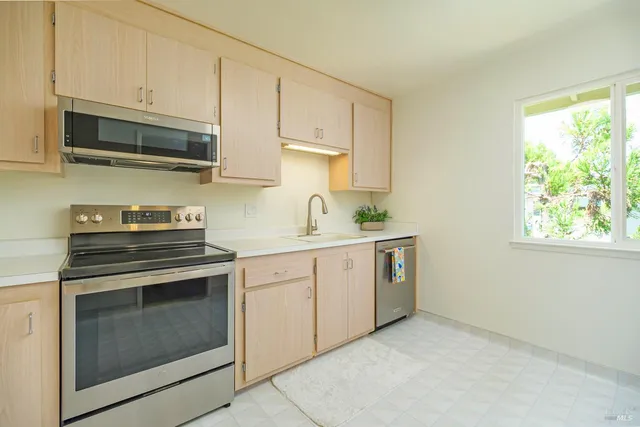 a kitchen with stainless steel appliances white cabinets and a stove top oven