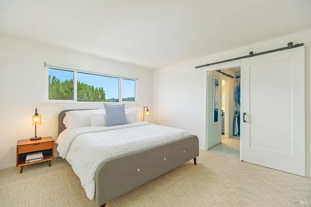 a spacious bedroom with a bed and a window