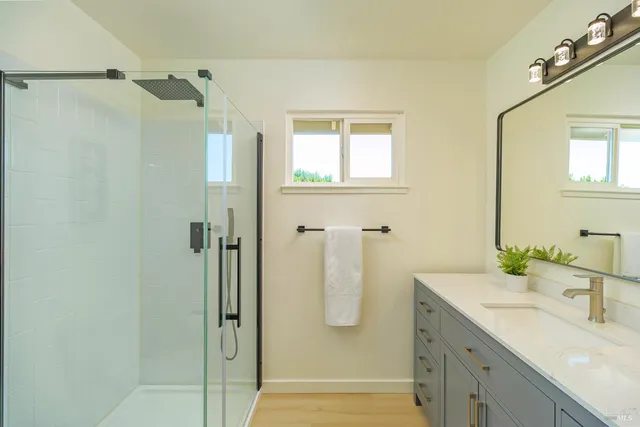 a bathroom with a double vanity sink a mirror and shower