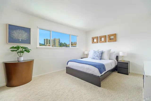 a bedroom with a bed and a potted plant