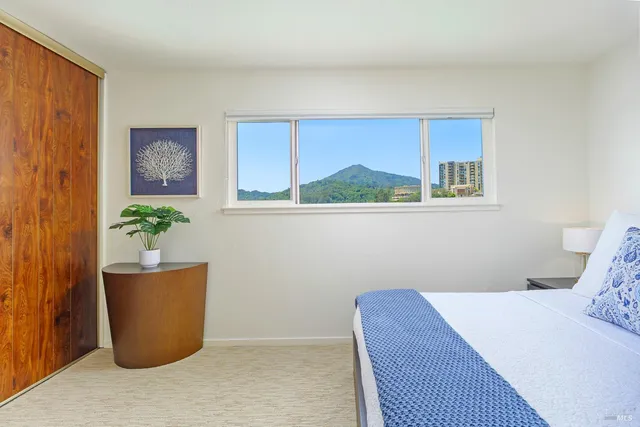 a bedroom with a bed and a potted plant