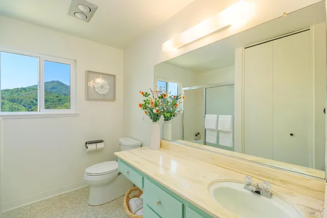 a bathroom with a granite countertop sink a toilet and a mirror