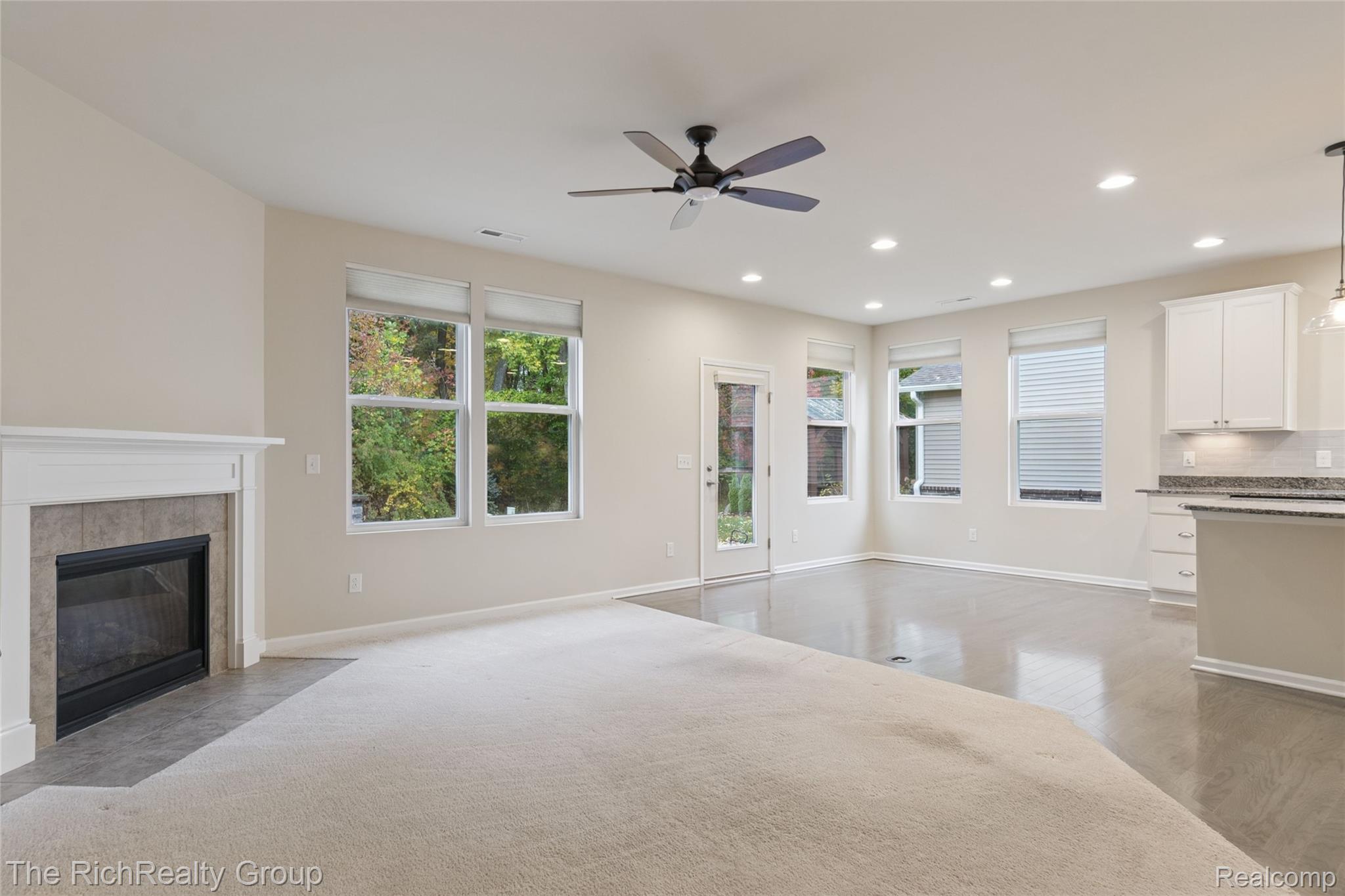 49534 Mapleton Road Canton, MI 48188 - Photo 15 of 37 Unfurnished living room featuring a ceiling fan, recessed lighting, a tile fireplace, and light wood-style floors