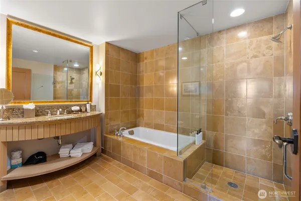 a bathroom with a tub a sink and shower