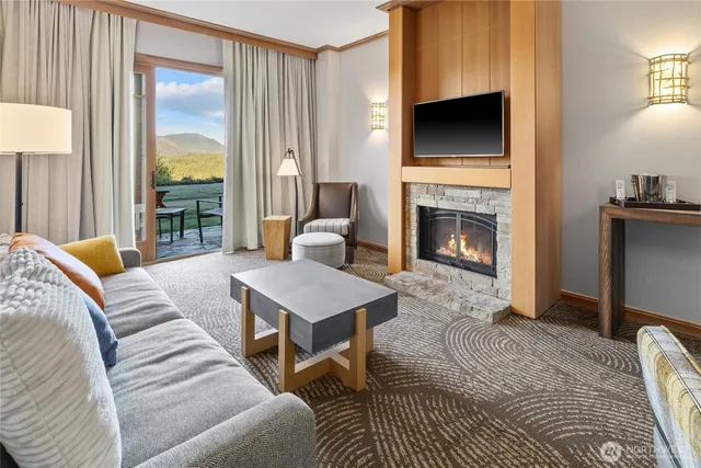 a living room with furniture a flat screen tv and a fireplace