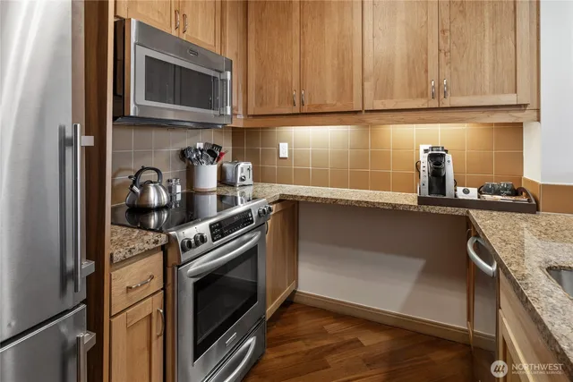 a kitchen with granite countertop a stove and a sink