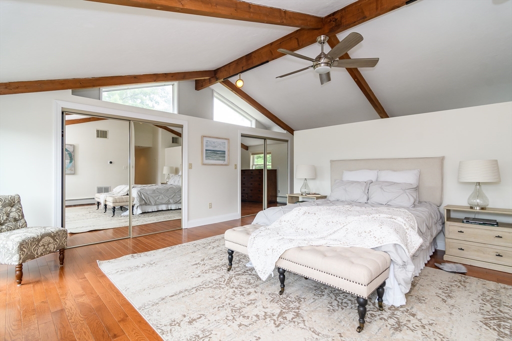 124 Everett Street Natick, MA 01760 - Photo 24 of 36 a spacious bedroom with a bed a couch and wooden floor