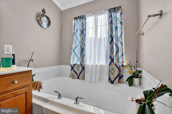 a bathroom with a tub sink and mirror