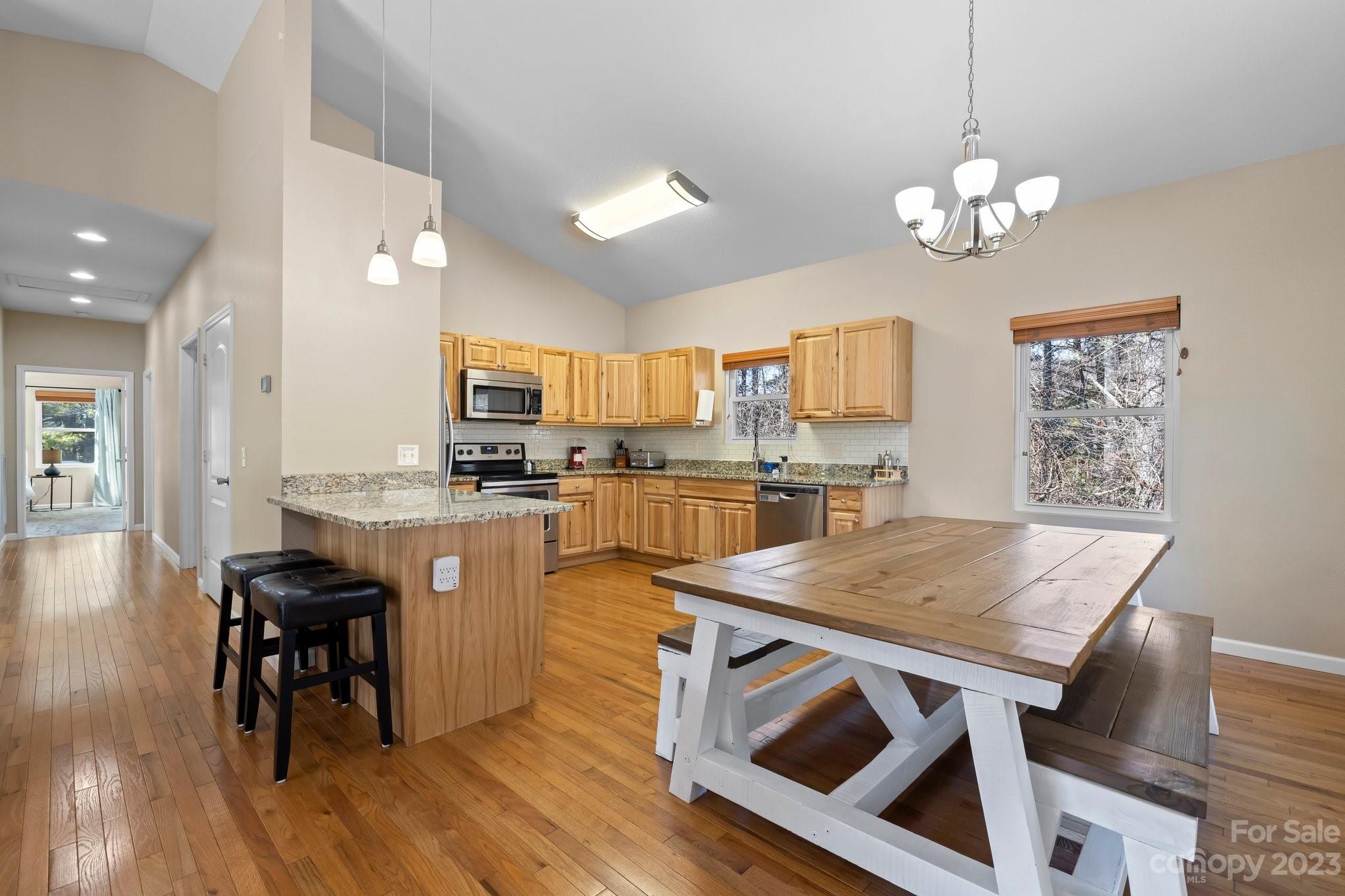 174 Diamond Point Canton, NC 28716 - Photo 13 of 43 a kitchen with stainless steel appliances granite countertop a stove top oven a refrigerator a sink and a dining table with wooden floor