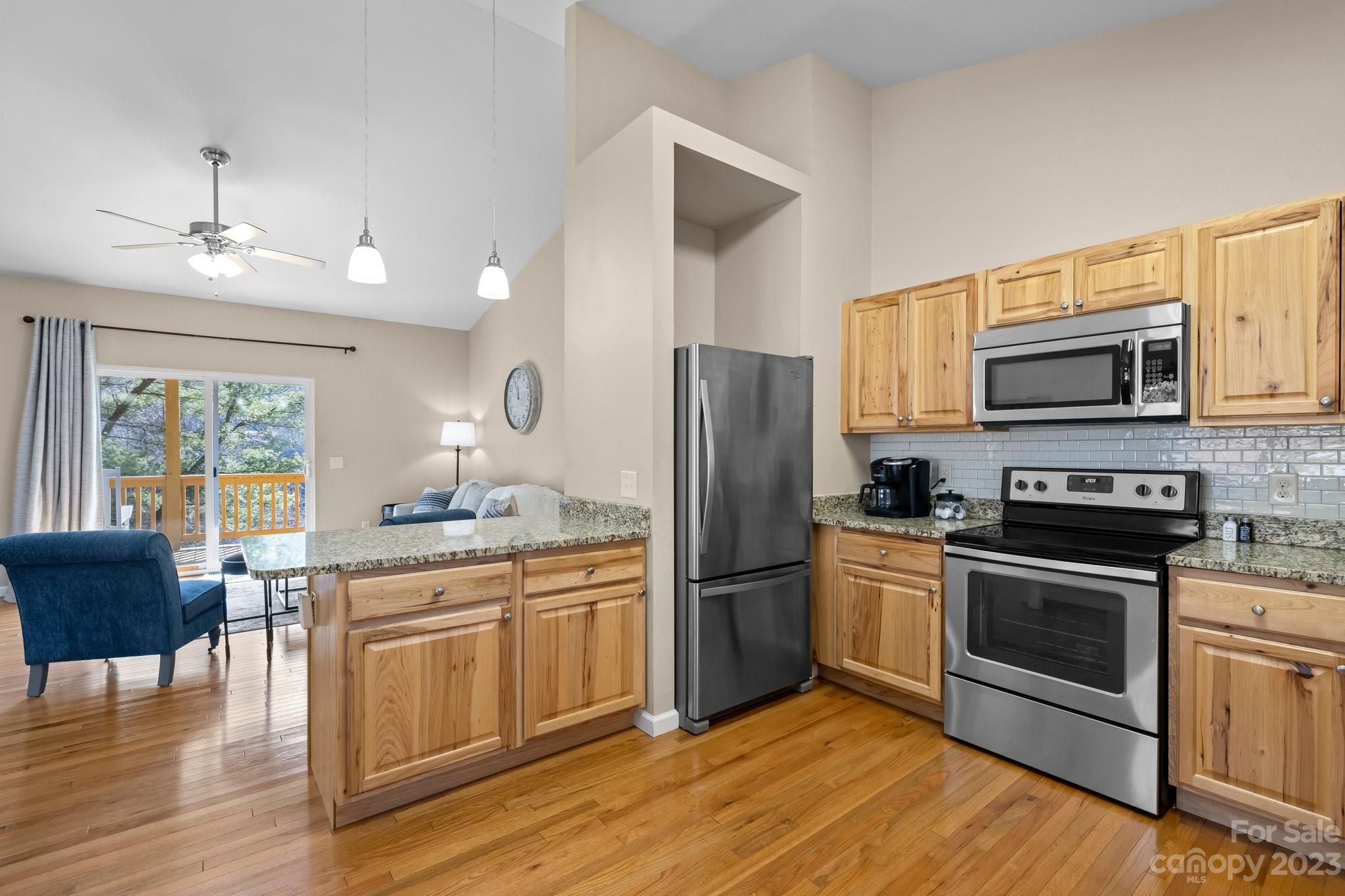 174 Diamond Point Canton, NC 28716 - Photo 16 of 43 a kitchen with stainless steel appliances a stove a sink dishwasher a refrigerator and a microwave oven with wooden floor