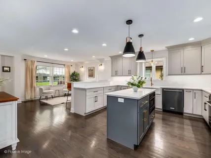 a kitchen with stainless steel appliances a sink stove and wooden floor