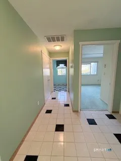 a kitchen with a checkered floor and white cabinets