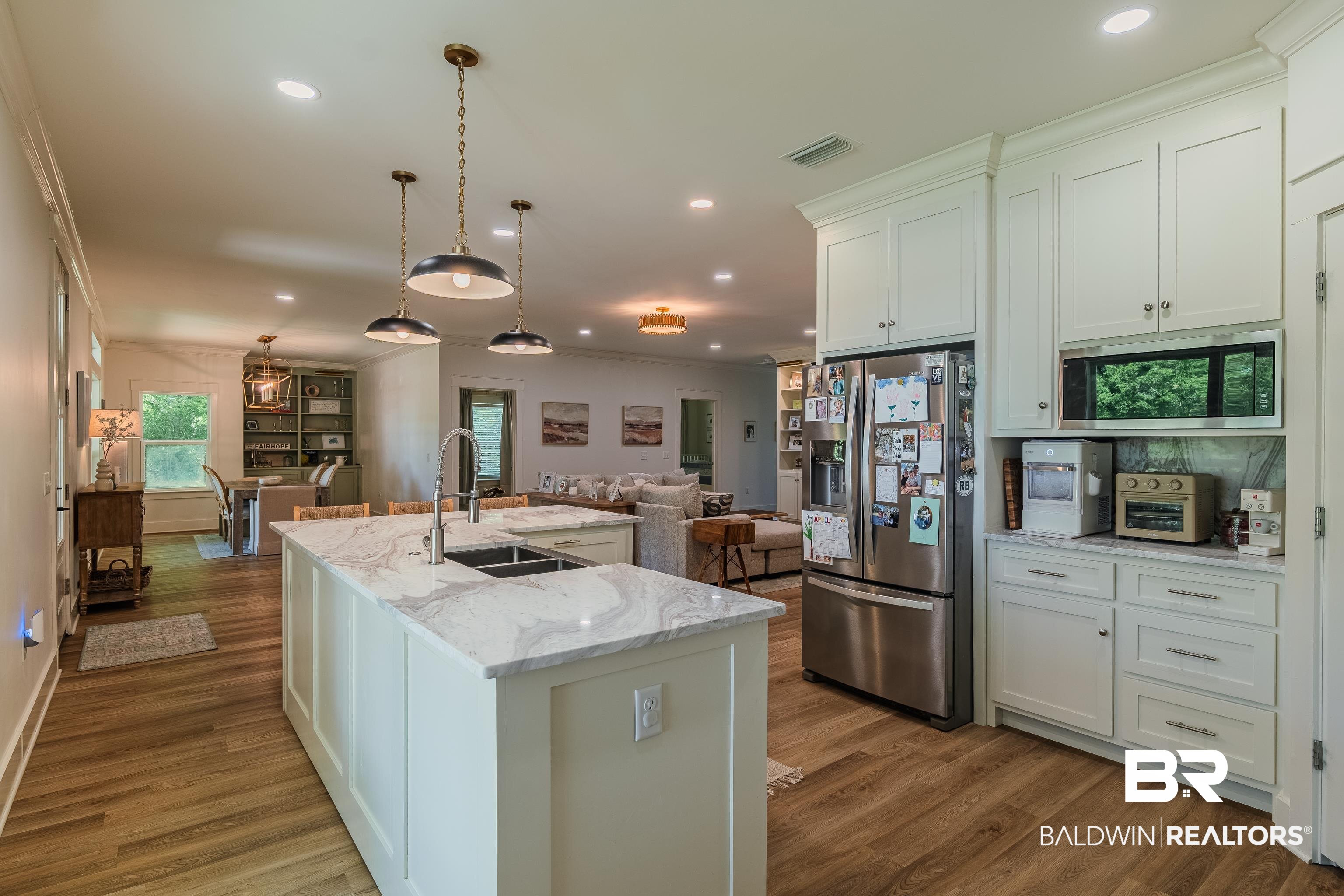 19121 Boothe Road Fairhope, AL 36532 - Photo 41 of 41 Kitchen with light stone countertops, stainless steel appliances, open floor plan, dark wood-style flooring, and crown molding