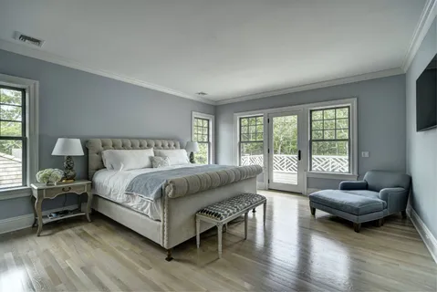 a bedroom with a bed and a couch next to a window