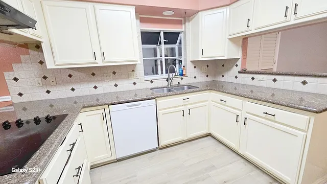 a kitchen with granite countertop white cabinets and white appliances