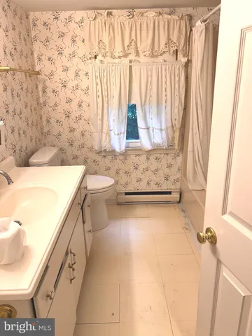 a bathroom with a granite countertop sink a toilet and bathtub