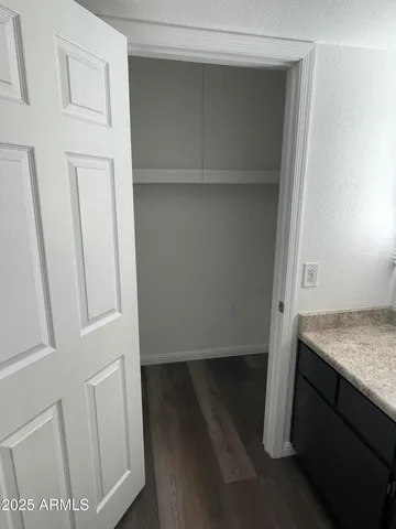 a view of walk in closet with empty racks