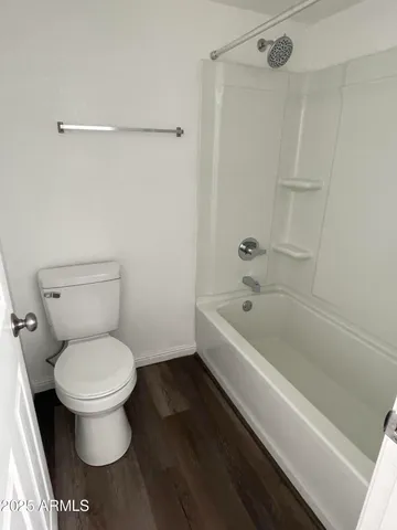a white toilet sitting next to a bath tub