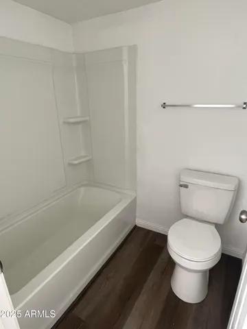 a white toilet sitting next to a bathtub