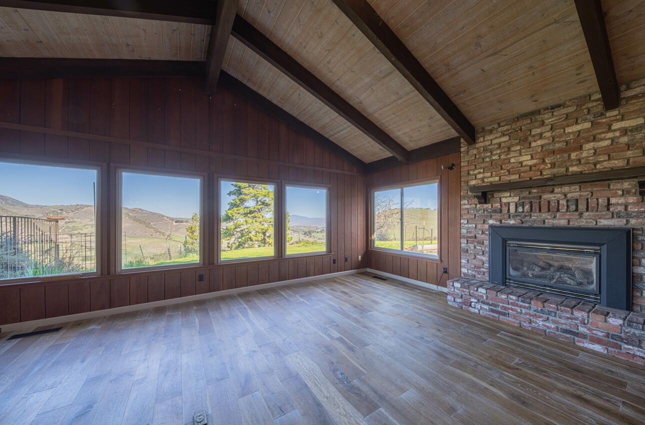52259 Pine Canyon Road King City, CA 93930 - Photo 15 of 62 an empty room with wooden floor fireplace and windows