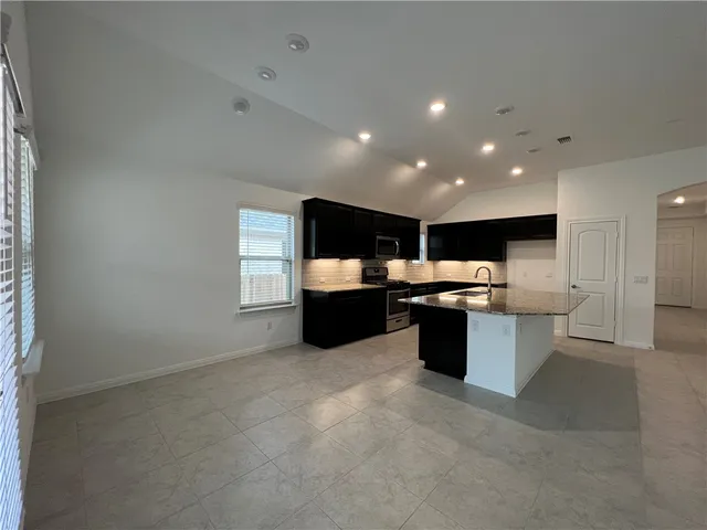 a kitchen with a sink cabinets and a window