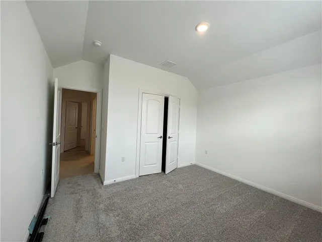 an empty room with closet and a bathroom