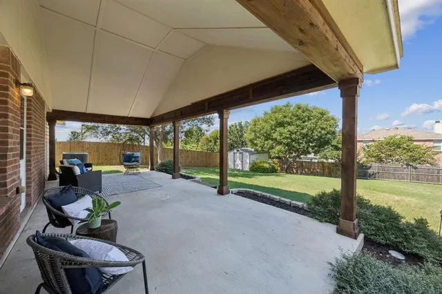 a view of a patio with table and chairs potted plants with floor to ceiling window
