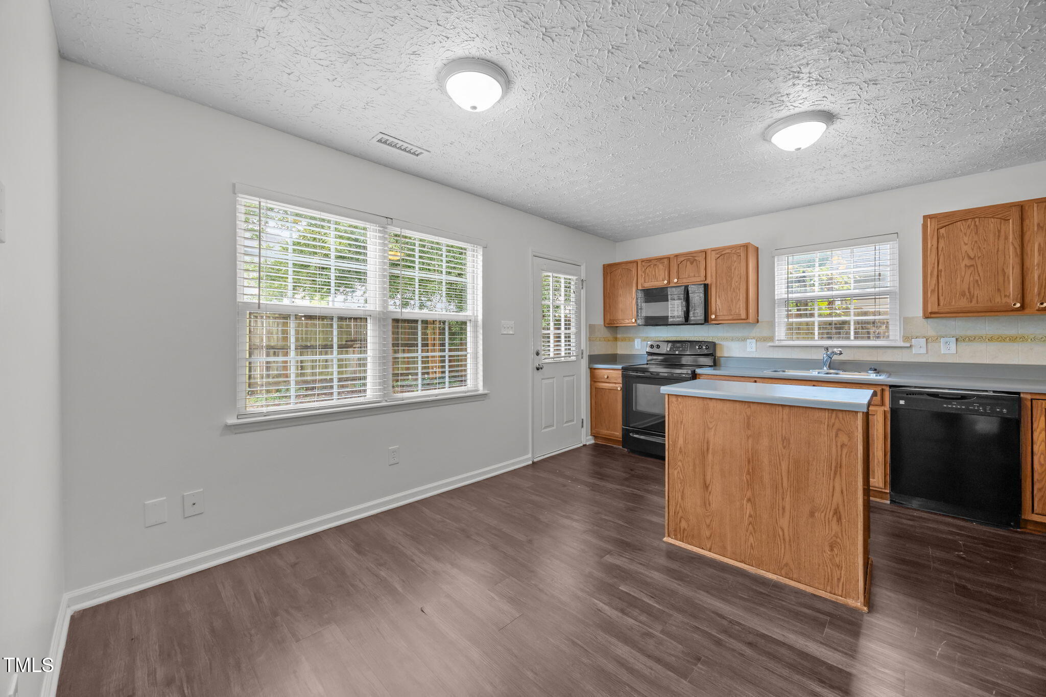 4232 Palafox Court Raleigh, NC 27604 - Photo 11 of 42 a kitchen with stainless steel appliances granite countertop a stove a sink dishwasher and a microwave oven with wooden floor