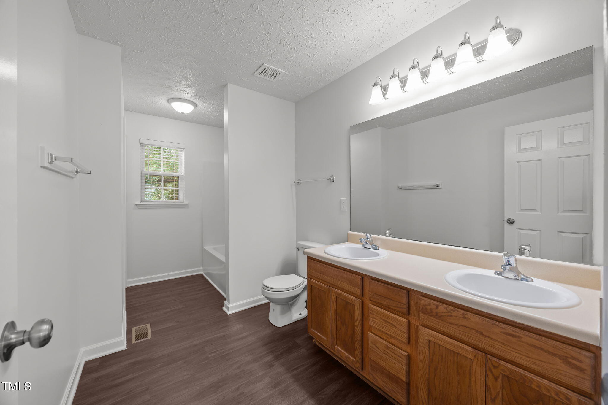 4232 Palafox Court Raleigh, NC 27604 - Photo 23 of 42 a spacious bathroom with a double vanity sink a toilet and a mirror