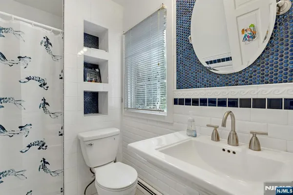 a bathroom with a granite countertop sink a mirror and shower