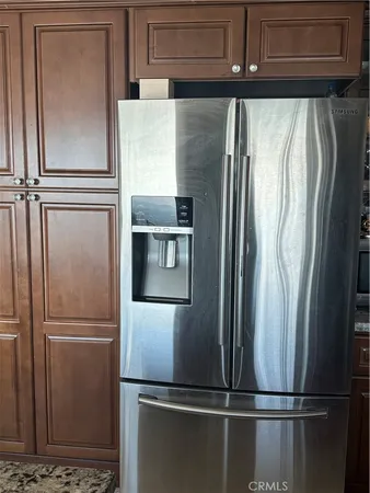 a metallic refrigerator freezer sitting in a kitchen