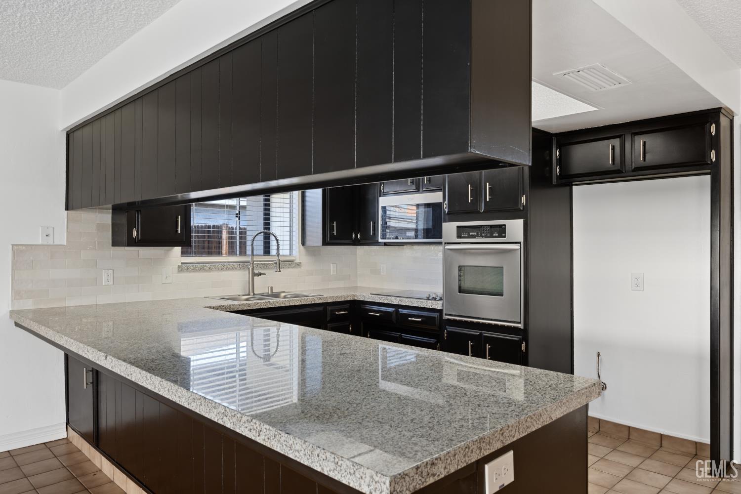 Undisclosed Address Bakersfield, CA 93312 - Photo 18 of 30 a kitchen with stainless steel appliances granite countertop a sink a microwave a stove and refrigerator