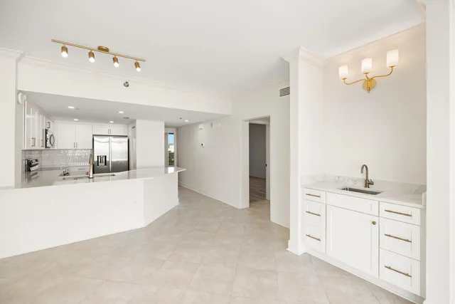 a large white kitchen with stainless steel appliances