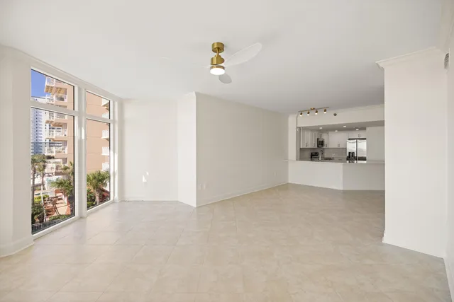 a kitchen with stainless steel appliances granite countertop a refrigerator a stove a sink a microwave and white cabinets with wooden floor