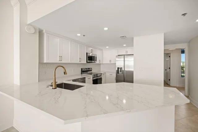a kitchen with stainless steel appliances granite countertop a refrigerator and a stove top oven
