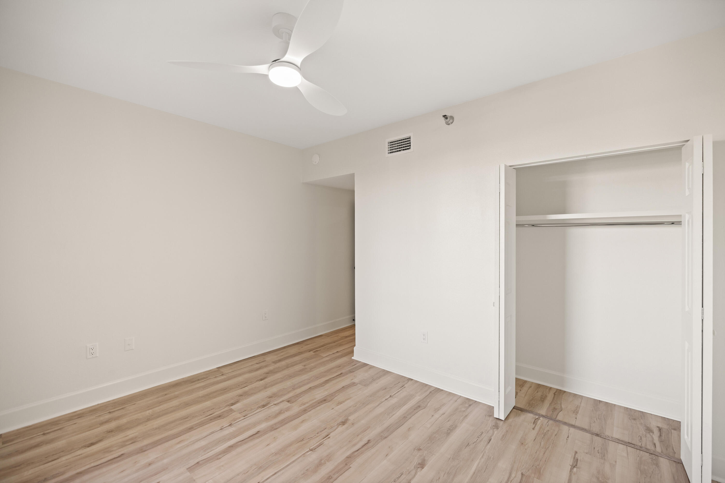 1018 Highway 98, Unit 340 Destin, FL 32541 - Photo 37 of 62 an empty room with wooden floor and fan