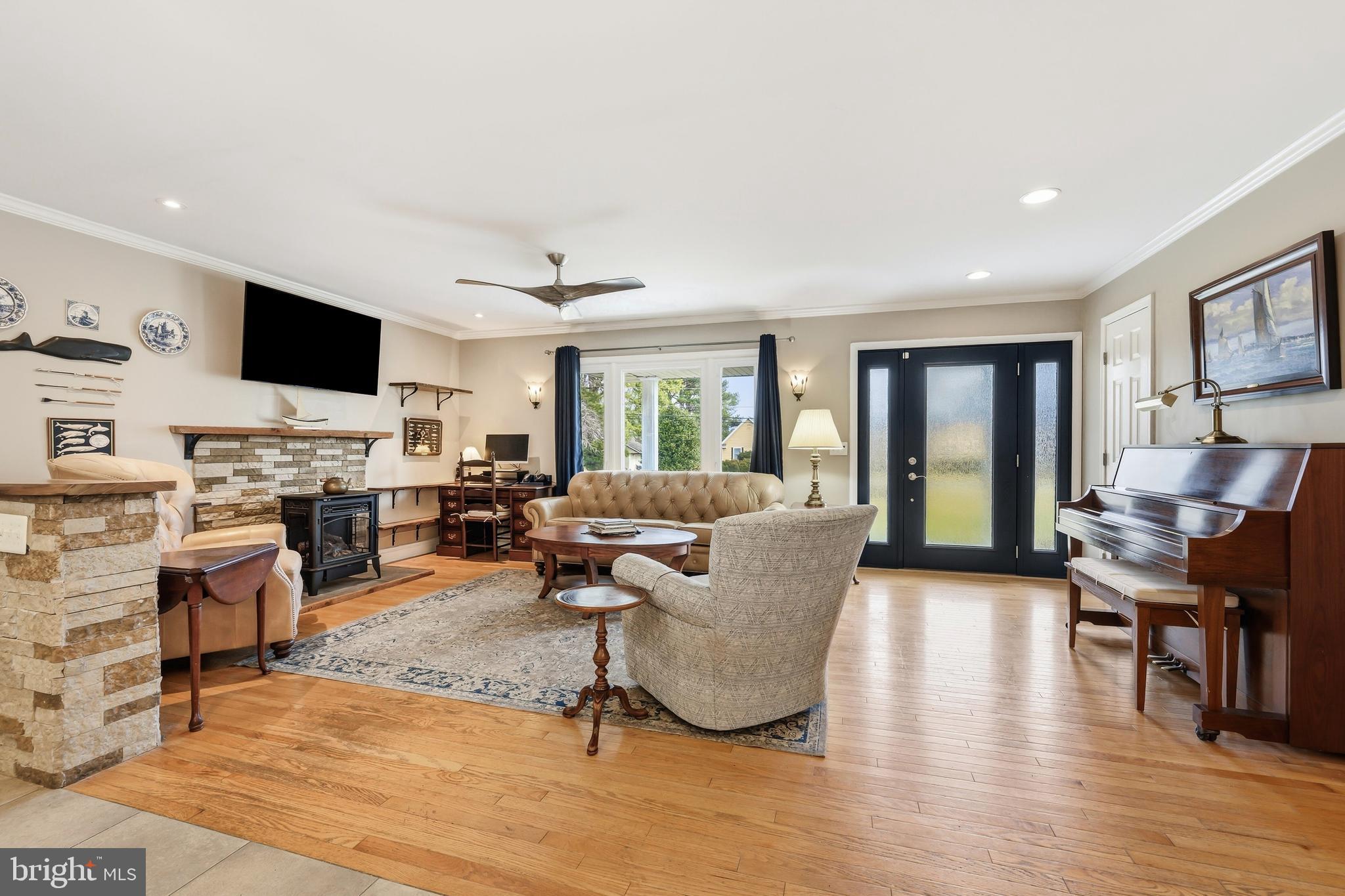 319 Wye Road Queenstown, MD 21658 - Photo 2 of 29 a living room with furniture flat screen tv and a fireplace