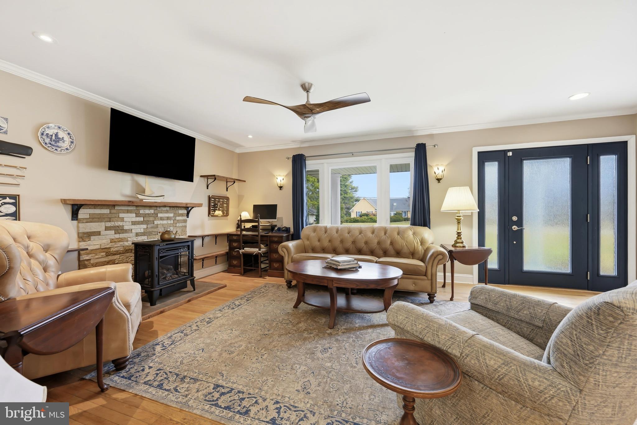 319 Wye Road Queenstown, MD 21658 - Photo 7 of 29 a living room with furniture a fireplace and a flat screen tv