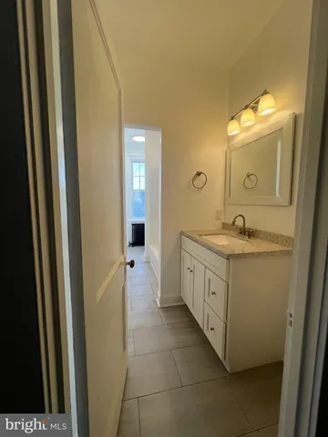 a spacious bathroom with a double vanity sink a mirror and a bathtub