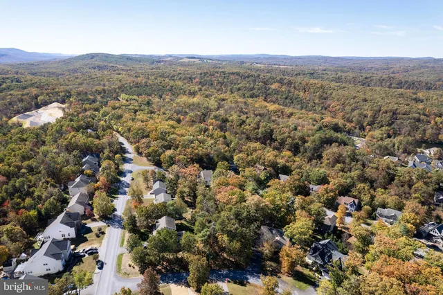 an aerial view of house with yard and mountain view in back