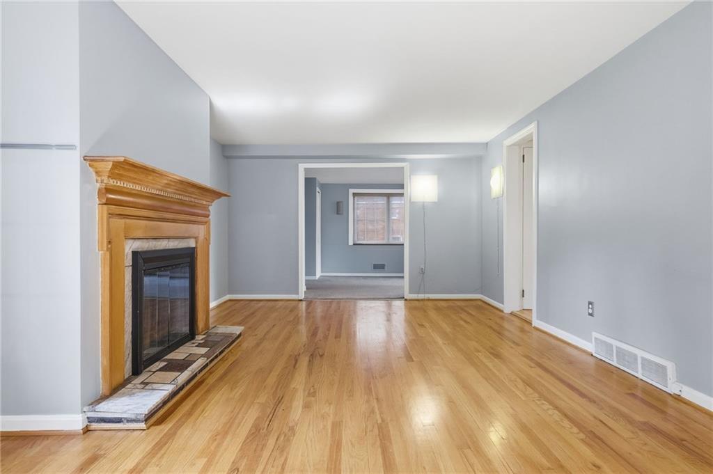 419 Burlington Road Pittsburgh, PA 15221 - Photo 6 of 38 a view of empty room with wooden floor and fireplace
