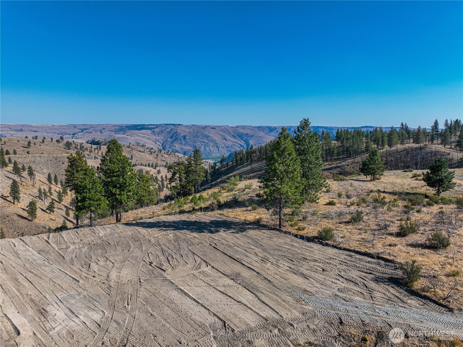 0 Evergreen Camp Road Chelan, WA 98816 - Photo 3 of 21 a view of a dry yard with wooden fence