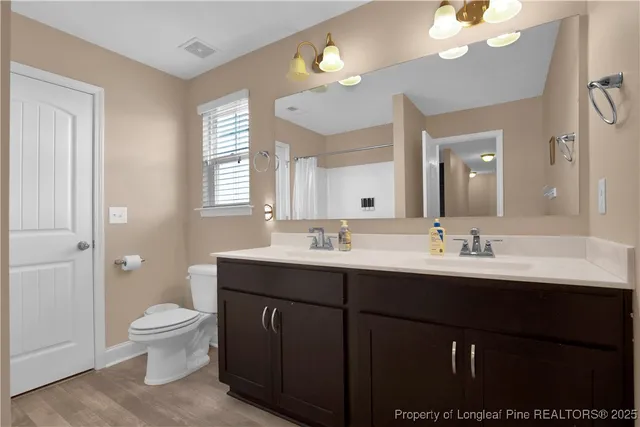 a bathroom with a sink a toilet and a mirror