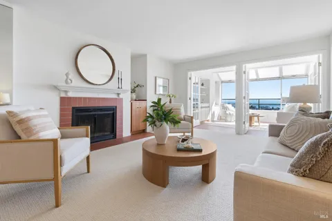 a living room with furniture a fireplace a window and a large mirror